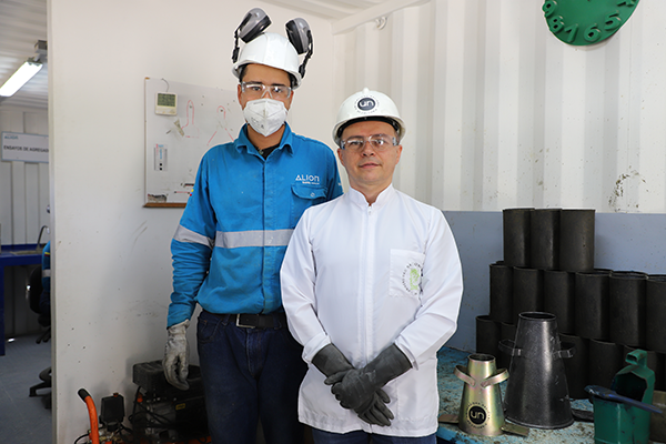 Samuel Andrés Restrepo Gallego, laboratorista de concreto de Alión, y Carlos Mauricio Bedoya Montoya, profesor de la Facultad de Arquitectura de la UNAL Medellín e inventor del dispositivo. Foto de Unimedios.