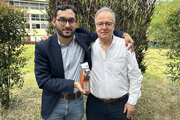 Juan Sebastián Orozco Cortés y el profesor Norman Giraldo Gómez con el reconocimiento obtenido. Foto Unimedios.