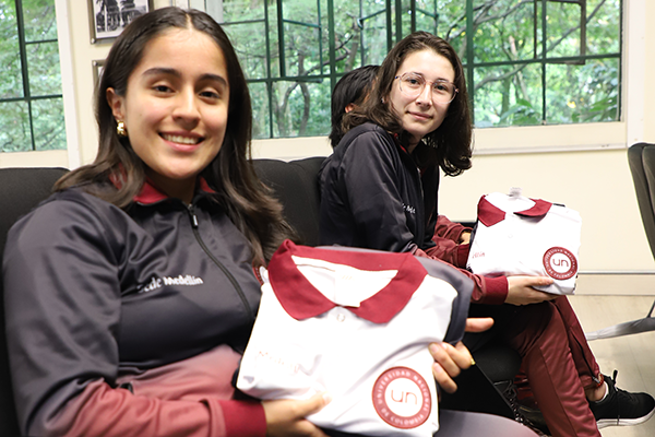 Karina Andrea Ardila Pulgarín, del equipo de balonmano femenino, y Valentina García, del grupo de Cuentería UNAL, recibieron los uniformes. Foto Unimedios.